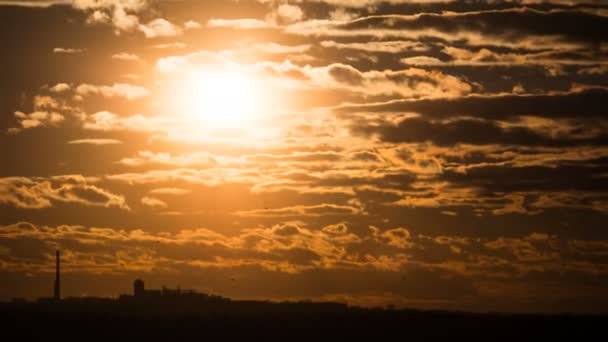 Dramatischer Sonnenuntergang über den Gewitterwolken und über Bäumen und Rohren der Anlage. Zeitraffer — Stockvideo
