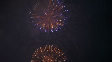 Gece gökyüzünde yanıp sönen havai fişekler. Ağır çekim