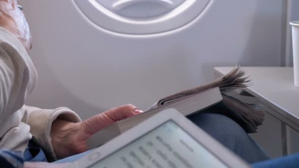 Пассажиры читают и решают кроссворды во время полета — стоковое видео