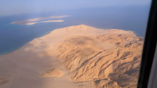 Bovenaanzicht van het vliegtuig venster op de Egyptische woestijn, bergen en rode zee met helder water — Stockvideo