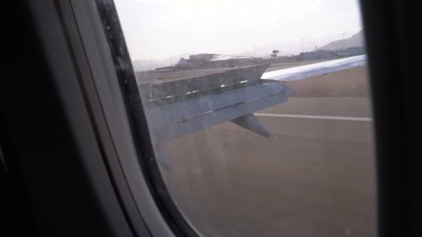 Landungsflugzeuge. Blick aus dem Fenster auf den Flügel eines Flugzeugs am Flughafen. — Stockvideo