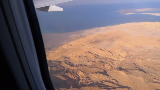 Vista aérea desde la ventana de la aeronave en el desierto de Egipto, las montañas y el mar Rojo con agua clara — Vídeo de stock