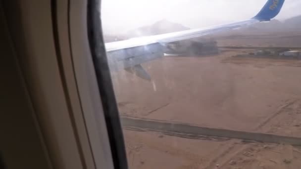 Landungsflugzeuge. Blick aus dem Fenster auf den Flügel eines Flugzeugs am Flughafen. — Stockvideo