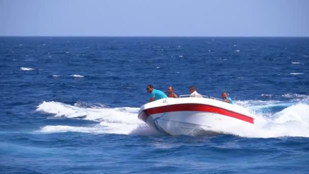 Motor båt med människor seglar längs vågorna i Röda havet. Slow motion — Stockvideo