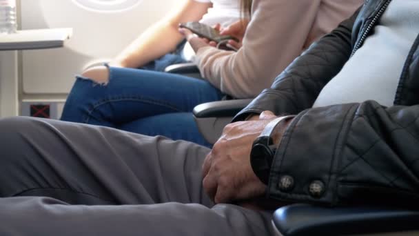 Manos de un anciano en el asiento de la aeronave durante el vuelo — Vídeo de stock