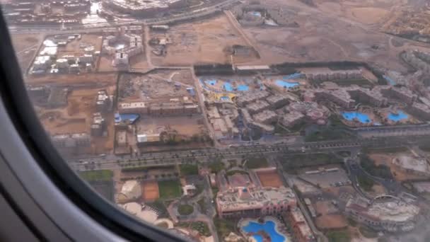 Vista dalla finestra dell'aeroplano sul resort tropicale con hotel esotici e piscine in Egitto Deserto — Video Stock