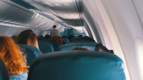 飞行期间坐在椅子上的客机机舱内的乘客 — 图库视频影像