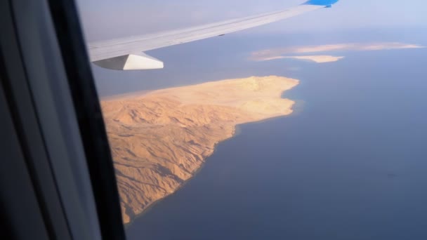 Vista aerea dalla finestra dell'aereo sul deserto d'Egitto, montagne e Mar Rosso con acqua limpida — Video Stock