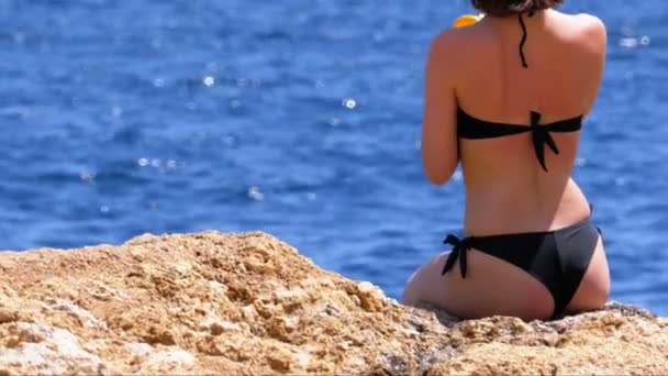 Sexy ragazza in costume da bagno con cocktail esotici seduta su una spiaggia contro il Mar Rosso in Egitto — Video Stock