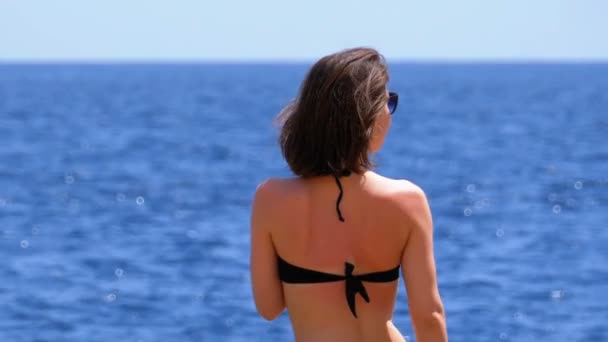 Sexy ragazza in costume da bagno con cocktail esotici seduta su una spiaggia contro il Mar Rosso in Egitto — Video Stock