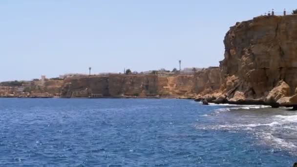 Rocky Beach en Egypte. Plage dans une baie sur le littoral avec des vagues dans la mer bleue et les récifs coralliens 