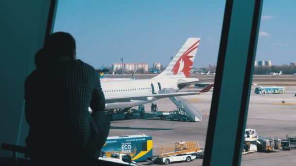 Silhouet van een kleine jongen en vader voor de Terminal venster kijken naar de vliegtuigen — Stockvideo