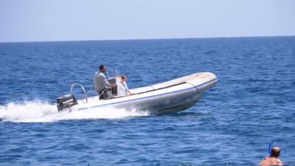 Barco a motor con la gente navega a lo largo de las olas en el mar rojo. Moción lenta — Vídeos de Stock