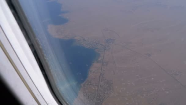 Vista dall'alto su una località balneare sulla riva del mare da un finestrino di un aereo — Video Stock