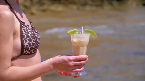 Giovane ragazza in costume da bagno con un cocktail esotico in mano sulla spiaggia in Egitto — Video Stock