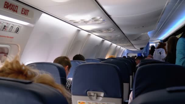 Pasajeros dentro de la cabina de los aviones de pasajeros sentados en las sillas durante el vuelo — Vídeo de stock