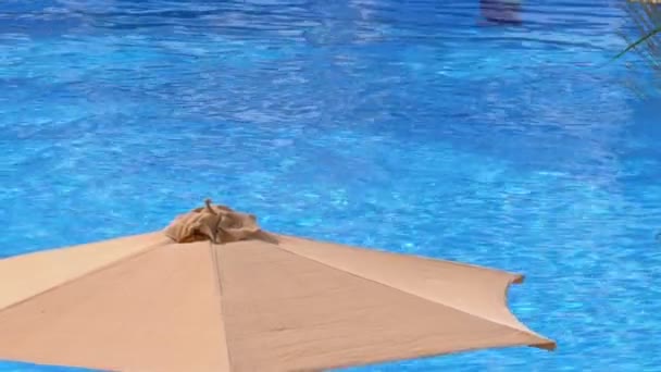 Parasole słoneczne przy basenie z błękitną wodą w hotelu Egiptu — Wideo stockowe