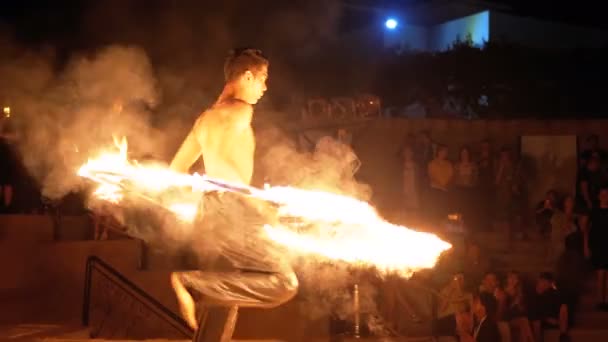 Zobrazit výkon na scéně Mladý muž tančí s ohnivou fanoušků v noční show. Zpomaleně — Stock video