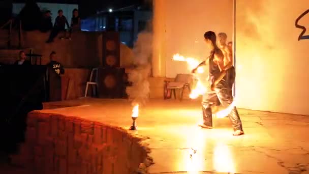 무대에서 화재 쇼 성능. 야간 쇼에서 불타는 팬들과 춤추는 청년 — 비디오