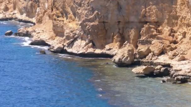 Rotsachtig strand in Egypte. Strand in een baai aan de kust met golven in de rode zee en koraalriffen. — Stockvideo