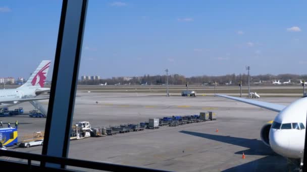 Вид на взлетно-посадочную полосу аэропорта с самолётами и обслуживающим персоналом — стоковое видео