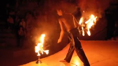 Sahnede Fire Show Performansı. Bir Gece Gösterisi Ateşli Hayranları ile Genç Adam Dancing