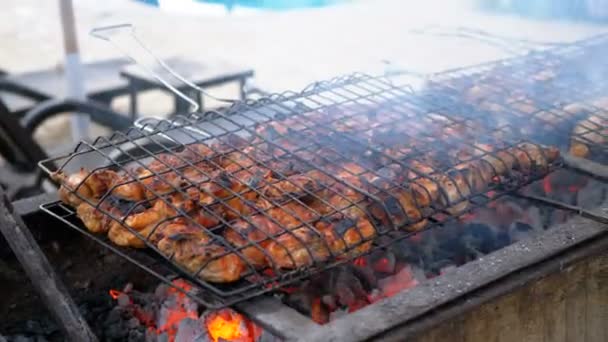 Los kebabs de pollo son cocinados en una parrilla grande por un cocinero en el hotel junto a la piscina con agua azul. Egipto — Vídeos de Stock