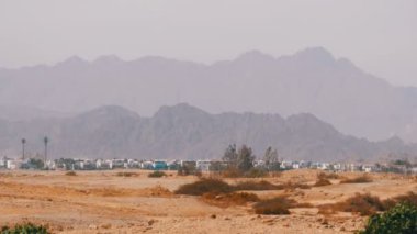 Mısır'da arka planda çöl dağlarında bina ve evlerin panoramik görünümü.