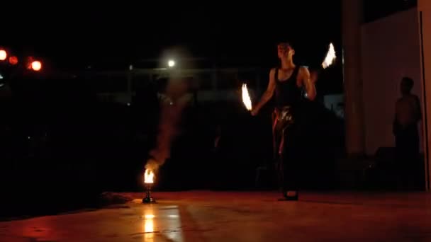 Вистава "Вогняне шоу" на сцені. Молода людина танцює з Вогненними шанувальниками на нічному шоу — стокове відео