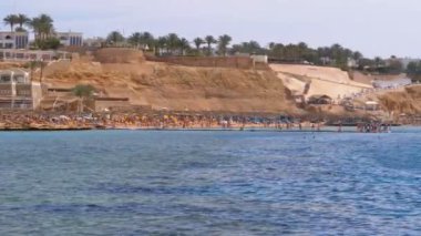 Mercan Resifi yakınındaki Kızıldeniz'deki Luxury Hotel'de Şemsiyeli ve Şezlonglu Plaj. Mısır.