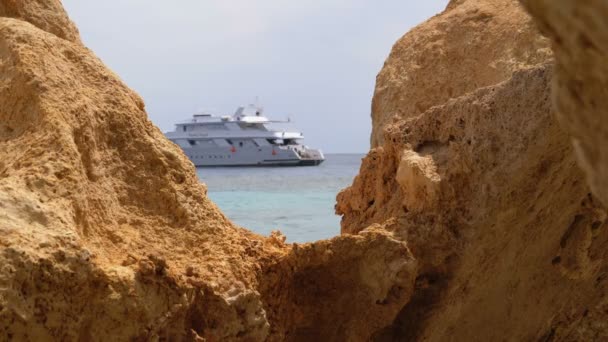 Rocky Beach s deštníky nedaleko Cliff na Rudém moři na korálovém útesu. Egypt. — Stock video