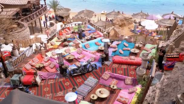 Felsstrand mit arabischen Cafés im Retro-Stil an der Küste mit Sonnenschirmen, Liegestühlen und Korallen. Ägypten — Stockvideo