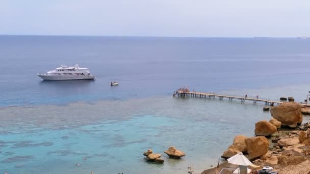 Rocky Beach with Umbrellas near Cliff on Red Sea at Coral Reef. Египет . — стоковое видео