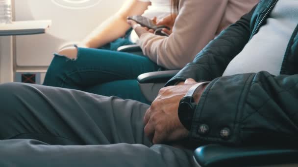 Händerna på en äldre man i flygplanets säte under flygningen — Stockvideo