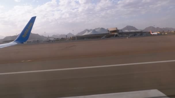 Vista da janela na asa de um avião que se move ao longo da pista no aeroporto após o desembarque — Vídeo de Stock