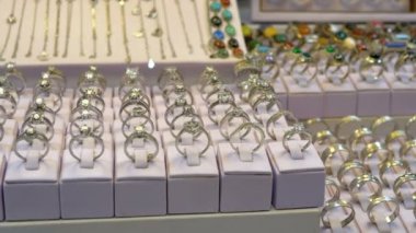 Mağaza vitrininde gümüşten yapılmış değerli taşlar ve takılar ile çeşitli gümüş yüzükler.