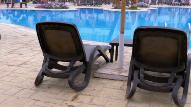 Sunbed Lounger cerca de la piscina con agua azul en el Resort de Egipto. — Vídeo de stock
