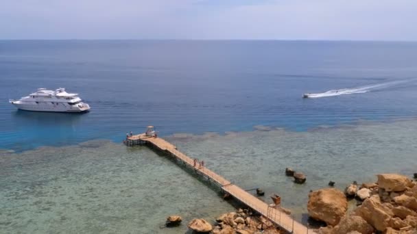 Vue panoramique sur la plage de Corail avec jetée et bateau de plaisance sur la mer Rouge au récif. Égypte . — Video
