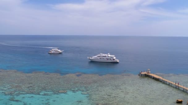 Panoramiczny widok na Coral Beach z molo i łodzi rekreacyjnych na Morzu Czerwonym na rafie. Egipt. — Wideo stockowe