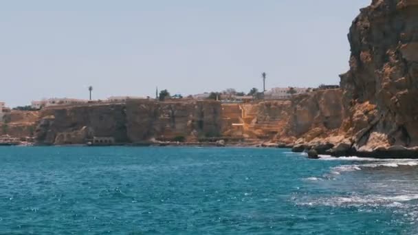 Rocky Beach en Egypte. Plage dans une baie sur le littoral avec des vagues dans la mer bleue et les récifs coralliens 