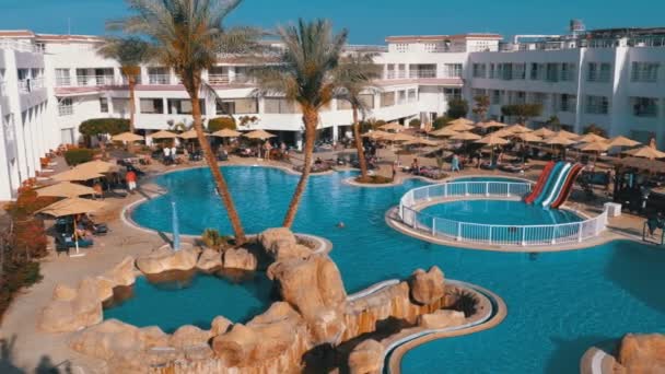 Sunny Hotel Resort z luksusowym błękitnym basenem, parasolami plażowymi i leżakami w Egipcie — Wideo stockowe