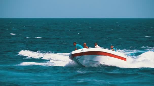 Motor båt med människor seglar längs vågorna i Röda havet. Slow motion — Stockvideo