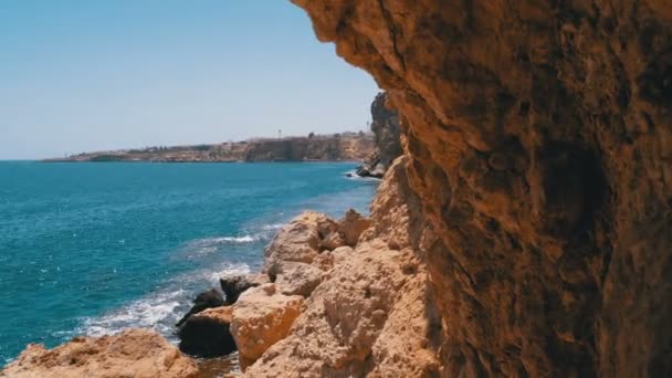 Rocky Beach en Egipto. Playa en una bahía en la costa con olas en el mar azul y arrecifes de coral — Vídeos de Stock