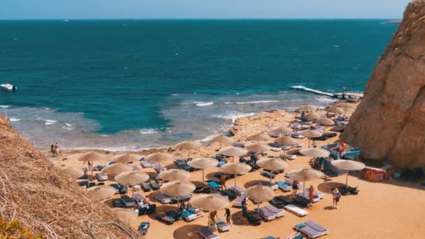 Rocky Beach v zálivu s deštníky a lehátky v Egyptě na Rudém moři. — Stock video