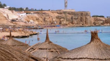 Mercan Resifi yakınlarındaki Kızıldeniz'de Güneş Şemsiyeleri ile Tropikal Plaj. Mısır.