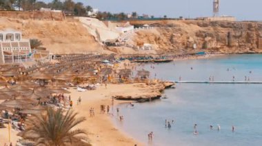 Mercan Resifi yakınındaki Kızıldeniz'deki Luxury Hotel'de Şemsiyeli ve Şezlonglu Plaj. Mısır.