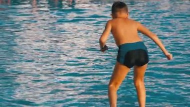 Mutlu Çocuk Mavi Su Havuzuna Atlıyor. Yavaş Çekim