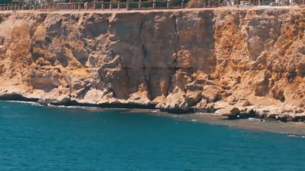 Rotsachtig strand in Egypte. Strand in een baai aan de kust met golven in de rode zee en koraalriffen. — Stockvideo