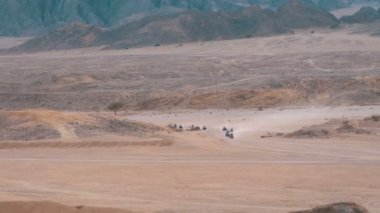 Dağların arka planında Mısır'da Çöl üzerinden Quad Bike Rides Grubu. Sürüş Avs.