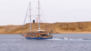 Kayalar arka planda Fırtınalı Denizi'nde Güzel Turistik Yat Yelkenler. Mısır